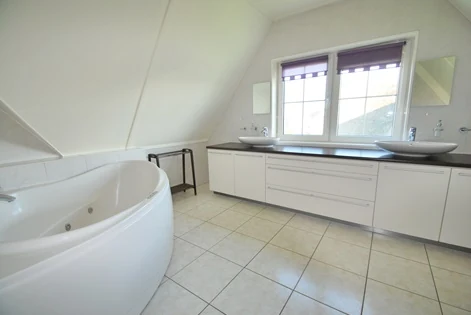 Badkamer met ligbad in BeachVilla Makkum