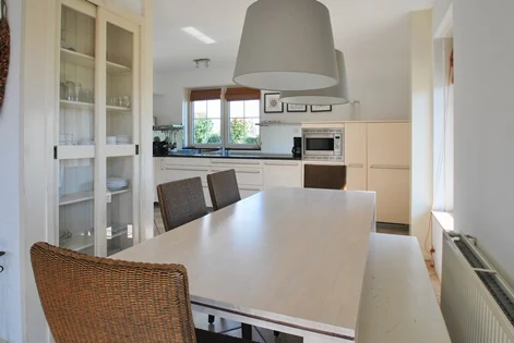 Eettafel en open keuken in BeachVilla Makkum
