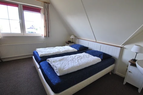 Slaapkamer onder het schuine dak in BeachVilla Makkum