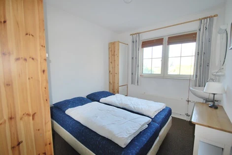 Slaapkamer met houten kast in BeachVilla Makkum