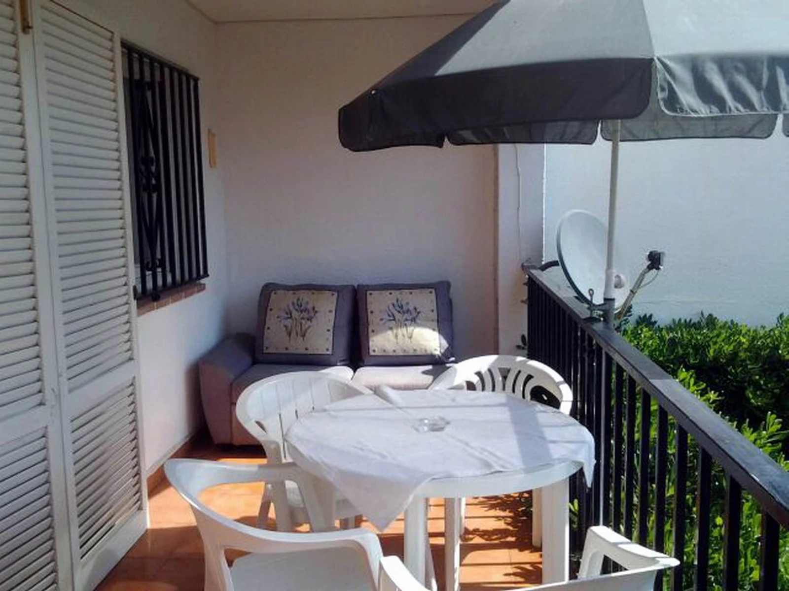 Overdekt terras met eettafel bij het appartement